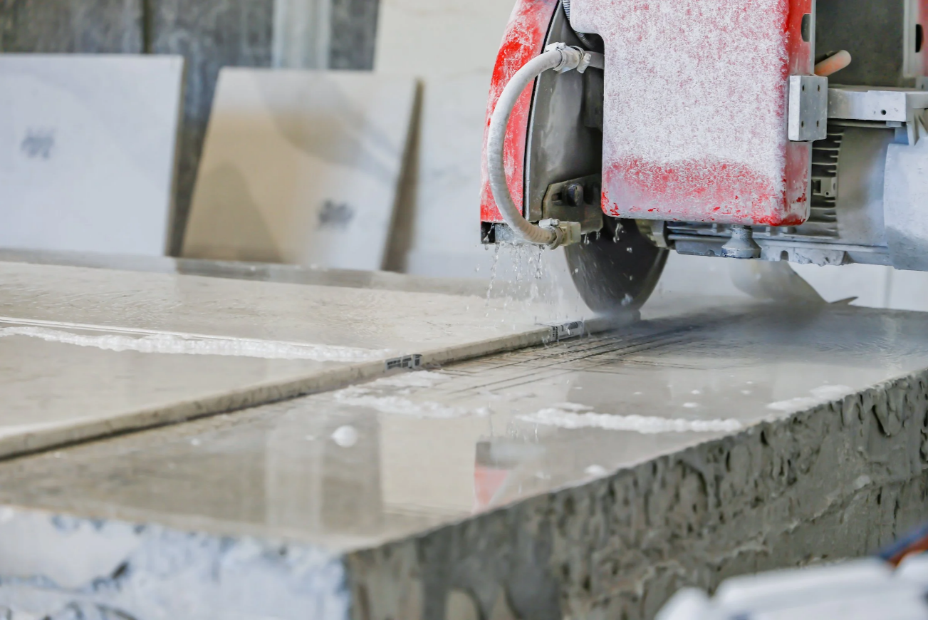 Stone slab being cut on a bridge saw at a countertop fabrication shop